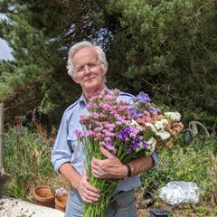 Photograph of Tony Lucas holding a bouquet of flowers.